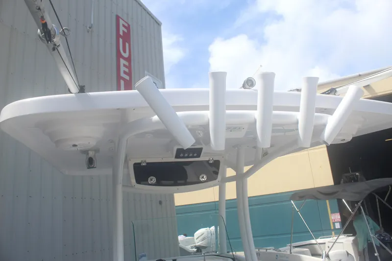 Slide: The Image of Century 2200 Center Console 2022 boat with rod holders and T-top near fuel station. - 26