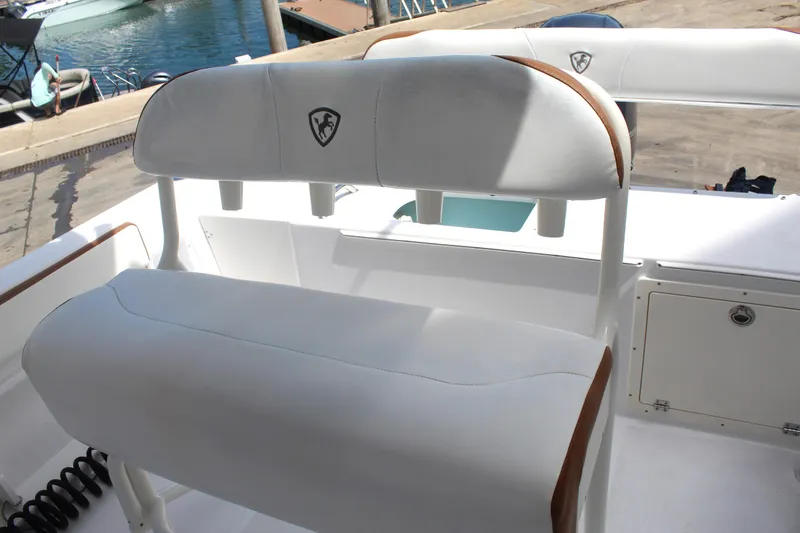 Slide: The Image of Century 2200 Center Console 2022 boat seating with white upholstery at a marina. - 42