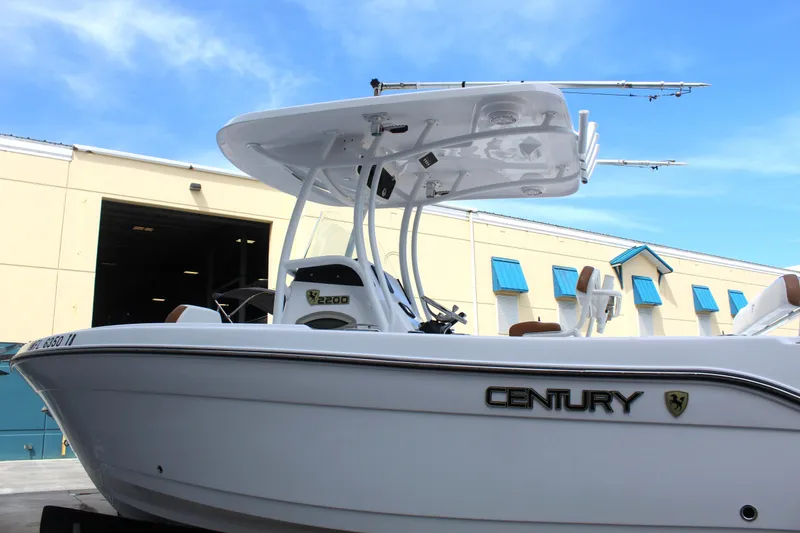 Slide: The Image of 2022 Century 2200 Center Console boat docked near a warehouse. - 7