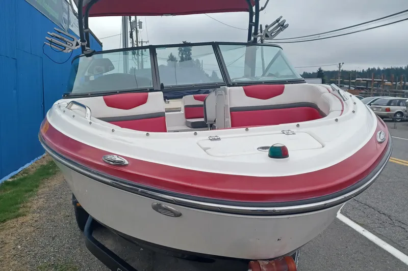 Slide: The Image of 2016 Chaparral Vortex 203 VRX boat with red and white seating, parked outdoors. - 2