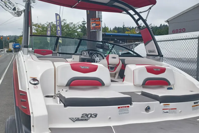 Slide: The Image of 2016 Chaparral Vortex 203 VRX boat with red and white seating, docked outdoors. - 3