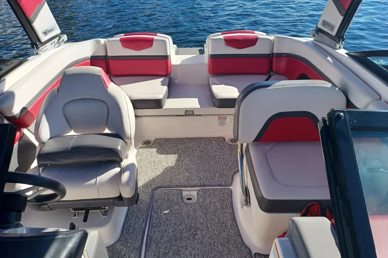 Slide: The Image of 2016 Chaparral Vortex 203 VRX boat interior with red and gray seating on water. - 8