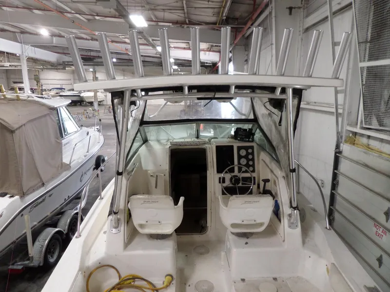 Slide: The Image of 1999 Sport-Craft 251 WA boat interior with dual seats and fishing rod holders. - 10