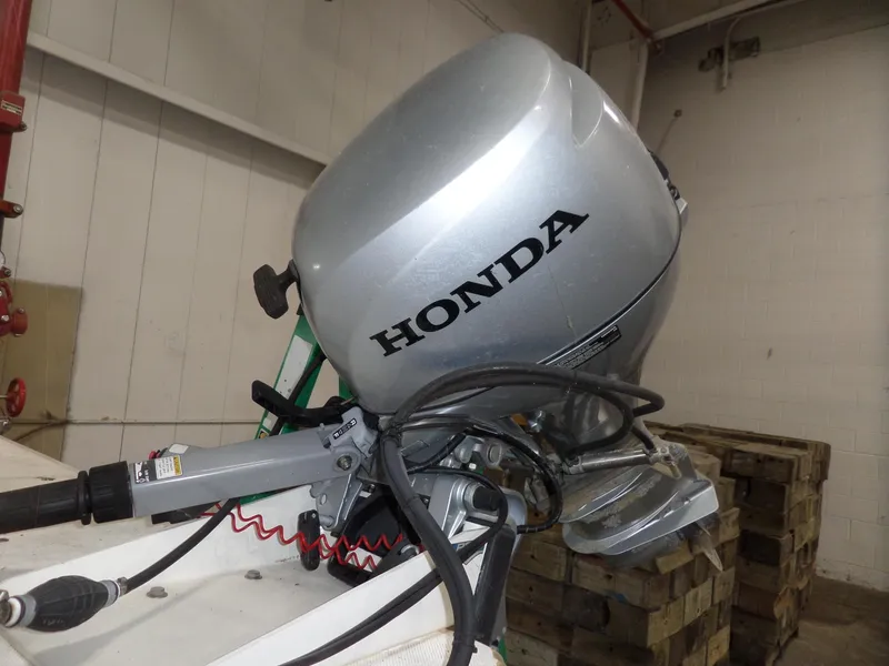 Slide: The Image of Honda outboard motor on 1999 Sport-Craft 251 WA boat in a garage. - 4