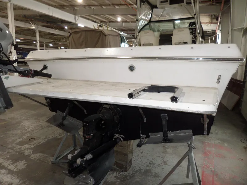 Slide: The Image of 1999 Sport-Craft 251 WA boat in a warehouse, showing the stern and engine area. - 7