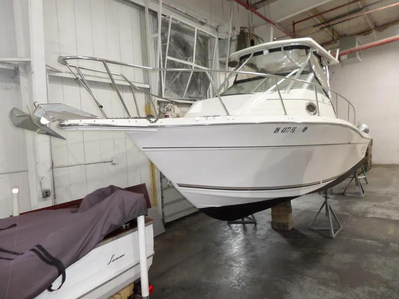 Slide: The Image of 1999 Sport-Craft 251 WA boat in indoor storage, elevated on stands. - 9