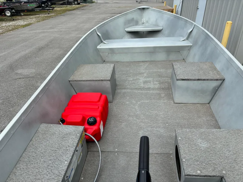 Slide: The Image of 2014 Alumacraft V14 boat interior with red fuel tank and seating. - 2