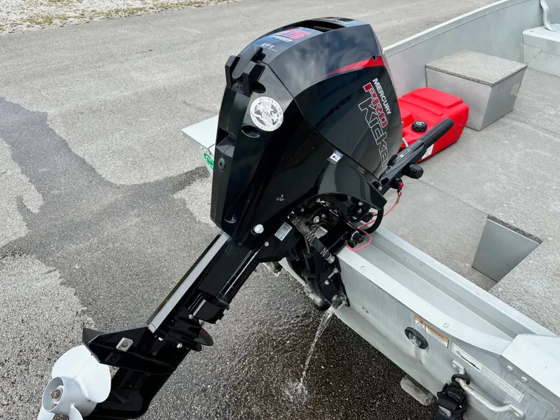 Slide: The Image of 2014 Alumacraft V14 boat with a Mercury outboard motor on a paved surface. - 4