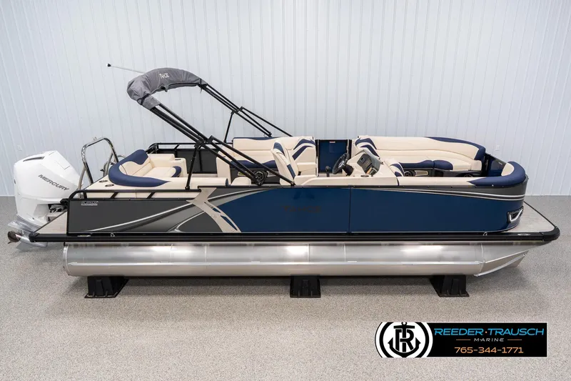 The Image of 2025 Tahoe LTZ EL pontoon boat with blue and beige seating, displayed indoors. - 0