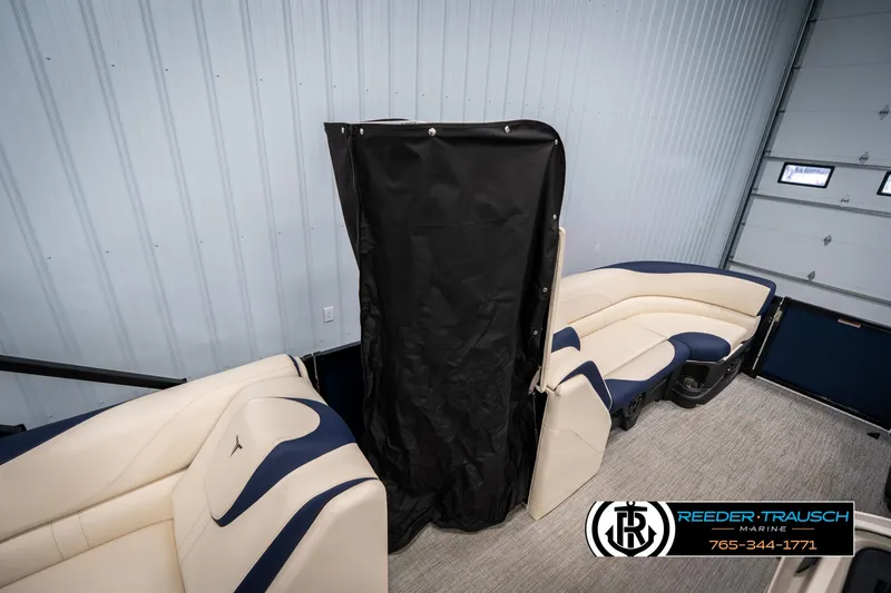 Slide: The Image of 2025 Tahoe LTZ EL boat interior with beige and navy seating, privacy curtain, and marine logo. - 20