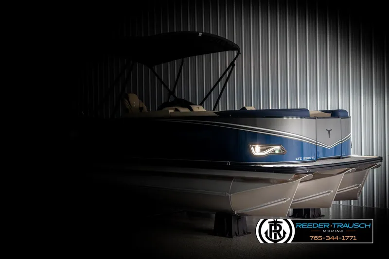 Slide: The Image of 2025 Tahoe LTZ EL pontoon boat in a dimly lit showroom, Reeder-Trausch Marine logo visible. - 3