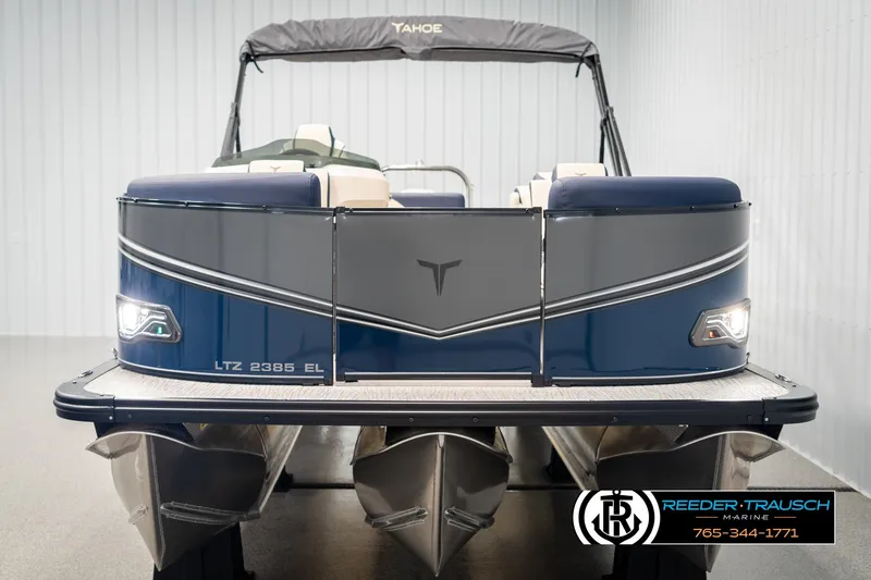 Slide: The Image of 2025 Tahoe LTZ EL pontoon boat, blue and gray design, displayed indoors at Reeder-Trausch Marine. - 7