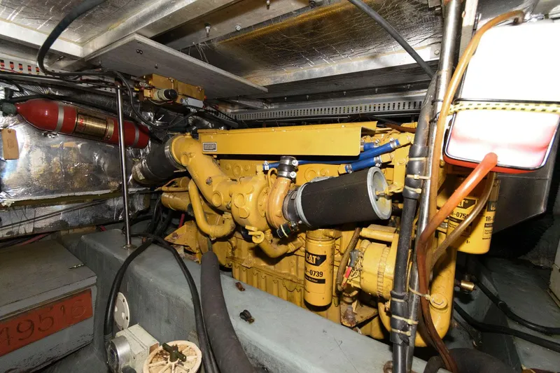 Slide: The Image of Engine room of 1994 Carver 440 Aft Cabin Motor Yacht, featuring a yellow engine. - 25