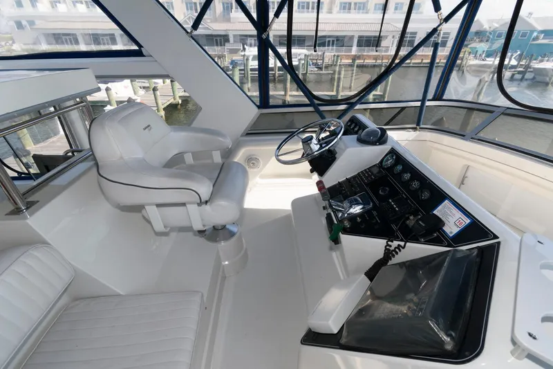 Slide: The Image of 1994 Carver 440 Aft Cabin Motor Yacht helm with steering wheel and control panel. - 6