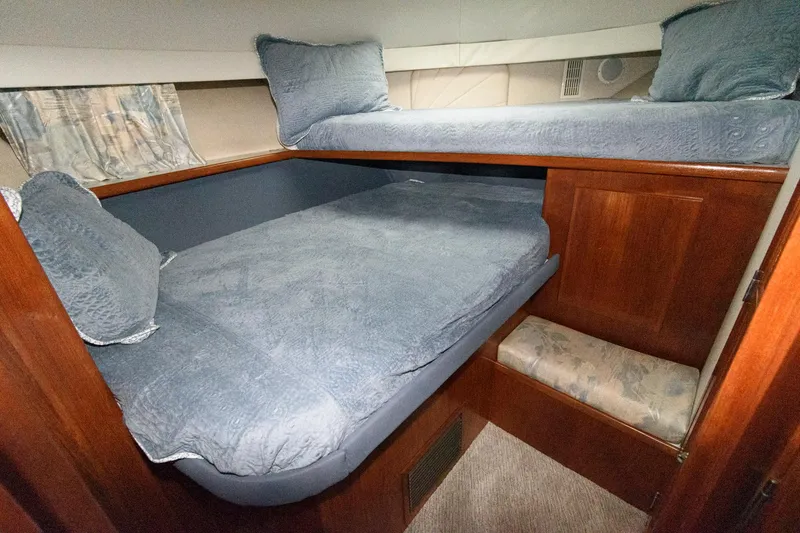 Slide: The Image of 1994 Carver 440 Aft Cabin Motor Yacht interior with cozy twin beds and wooden cabinetry. - 20