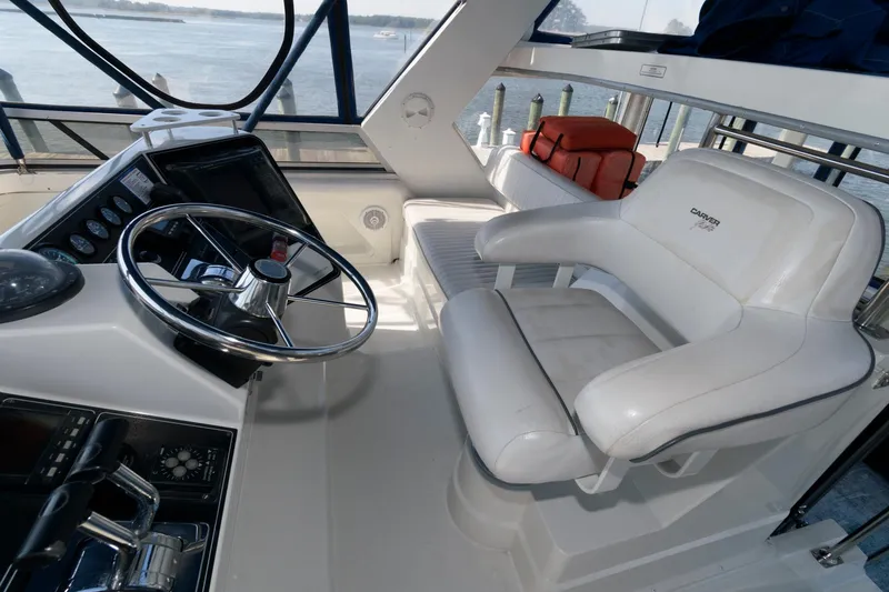 Slide: The Image of 1994 Carver 440 Aft Cabin Motor Yacht helm with steering wheel and seating. - 8