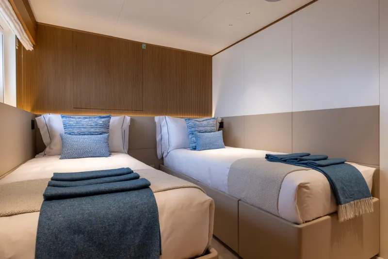 Slide: The Image of Luxurious twin bedroom on 2025 Benetti Oasis 34M yacht, featuring elegant blue accents. - 37