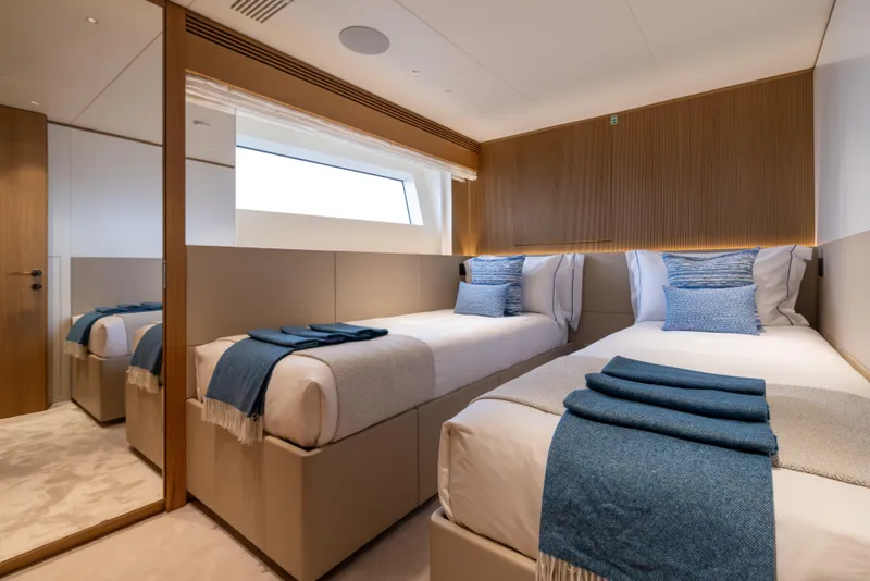 Slide: The Image of Luxurious twin bedroom on 2025 Benetti Oasis 34M yacht with modern decor and blue accents. - 38