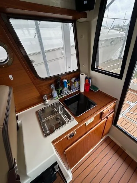 Slide: The Image of 2023 Ranger Tugs R23 interior with compact kitchen, sink, and wooden cabinetry. - 10