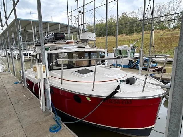 Slide: The Image of 2023 Ranger Tugs R23 boat docked in a marina, featuring a vibrant red hull. - 5