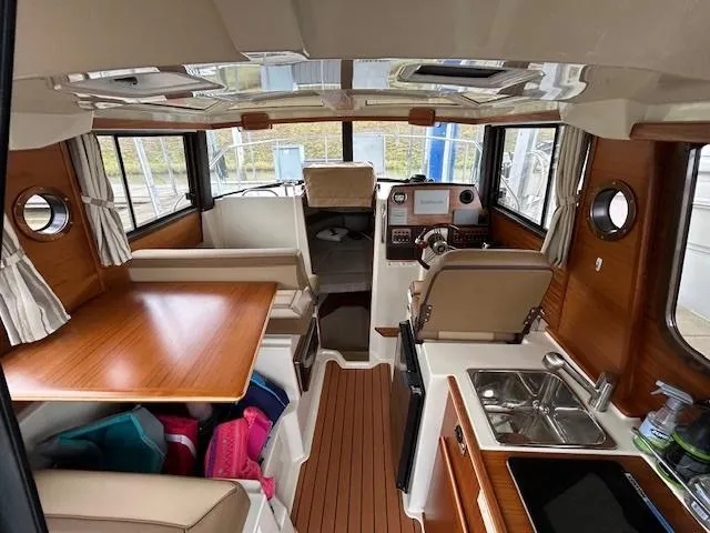 Slide: The Image of 2023 Ranger Tugs R23 interior with wood accents, dining area, and helm station. - 9