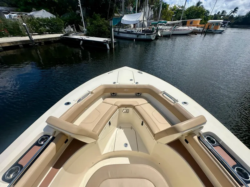 Slide: The Image of 2021 Scout 305 LXF boat docked in a serene marina setting. - 4