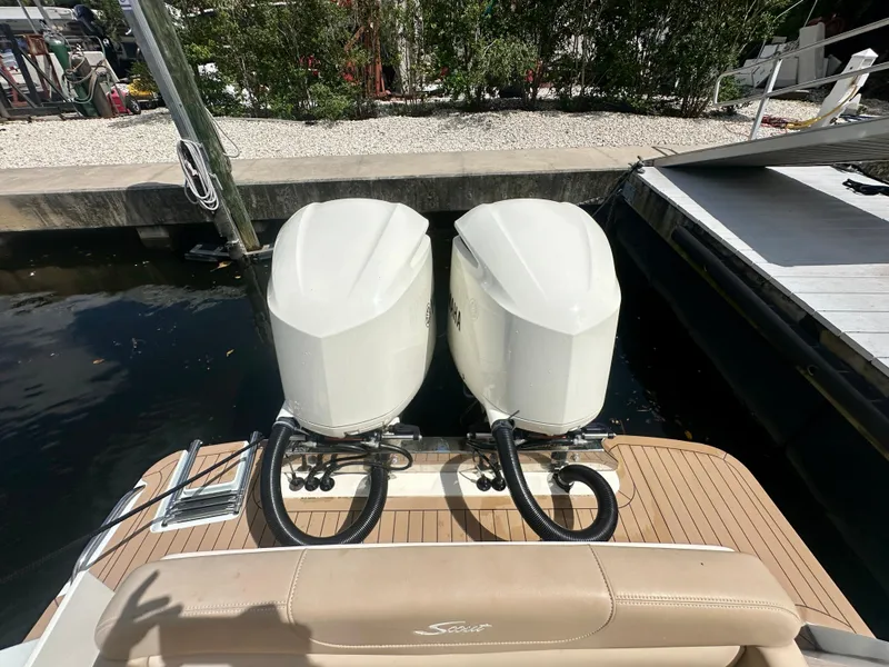 Slide: The Image of 2021 Scout 305 LXF boat with dual outboard engines docked at marina. - 7