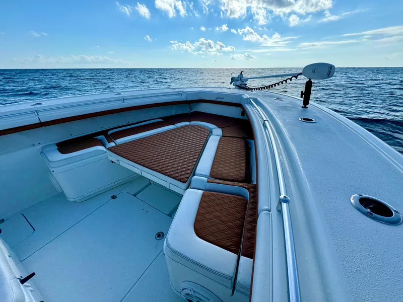 Slide: The Image of 2015 Yellowfin 42 boat with brown seating, cruising on open ocean under blue sky. - 33