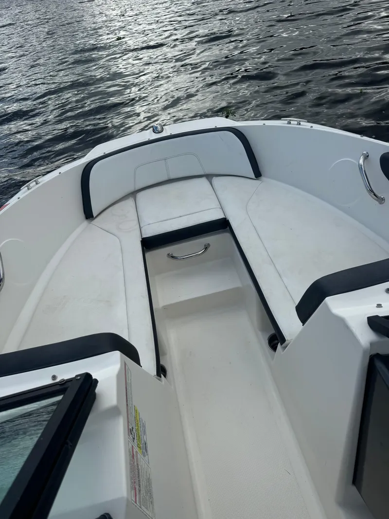 Slide: The Image of 2017 Sea Ray 19 SPX boat interior with cushioned seating on calm water. - 4