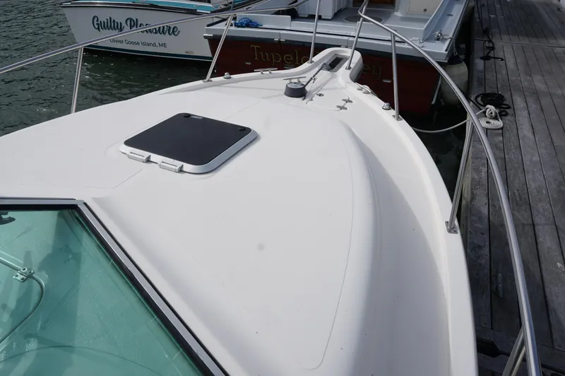 Slide: The Image of 2002 Pursuit 2865 Denali boat docked, showing bow and deck details. - 10