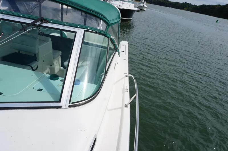 Slide: The Image of 2002 Pursuit 2865 Denali boat with green canopy on calm water. - 13