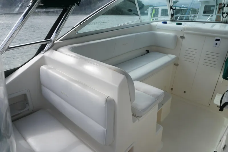 Slide: The Image of 2002 Pursuit 2865 Denali boat interior with white seating and windows. - 14