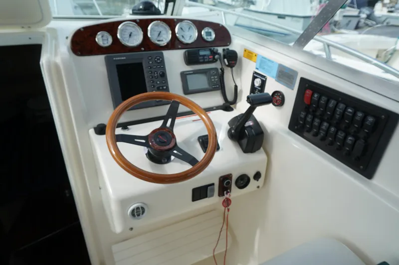 Slide: The Image of 2002 Pursuit 2865 Denali boat dashboard with steering wheel and navigation instruments. - 16