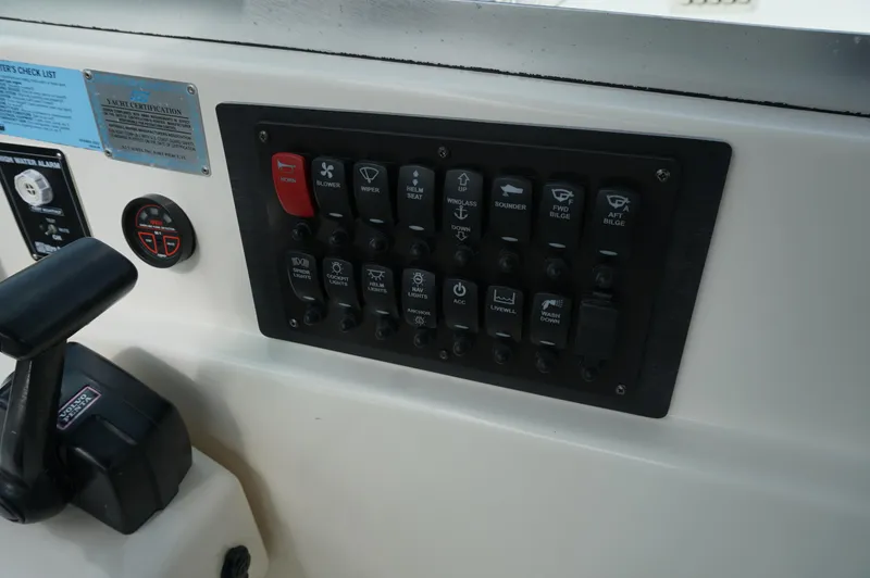 Slide: The Image of Control panel of a 2002 Pursuit 2865 Denali boat with various switches and gauges. - 17