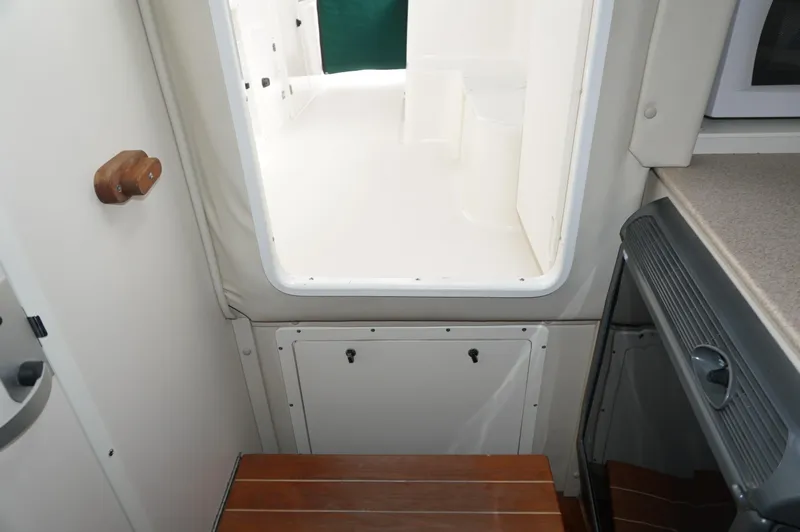 Slide: The Image of Interior view of 2002 Pursuit 2865 Denali boat, featuring cabin entrance and wooden steps. - 21