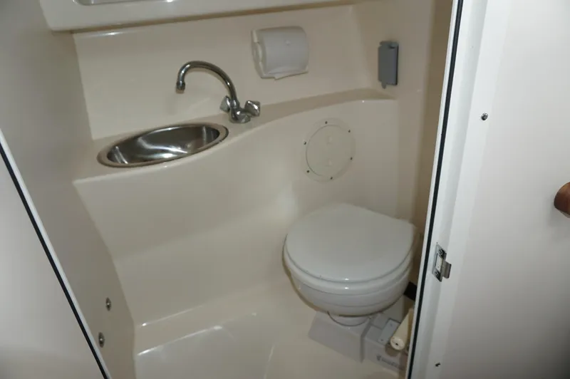 Slide: The Image of Compact bathroom in 2002 Pursuit 2865 Denali boat with sink and toilet. - 22