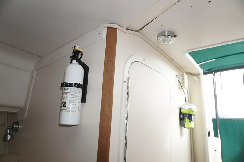 Slide: The Image of Interior of 2002 Pursuit 2865 Denali boat with fire extinguisher and safety equipment. - 23