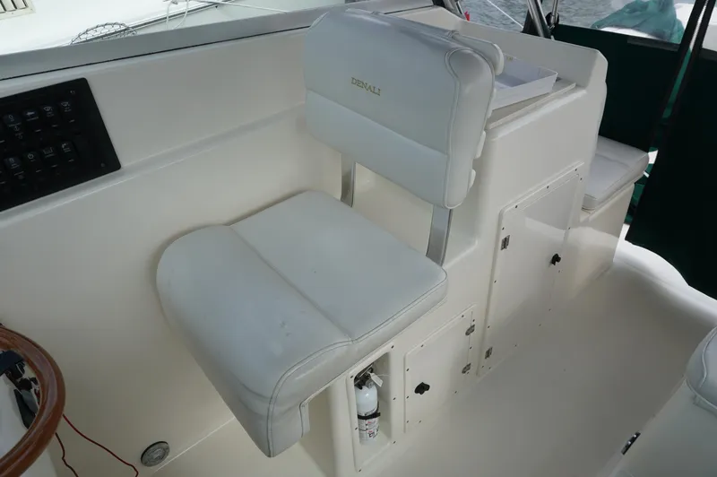 Slide: The Image of 2002 Pursuit 2865 Denali boat interior with white seating and control panel. - 24