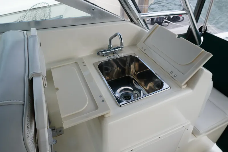 Slide: The Image of 2002 Pursuit 2865 Denali boat interior with sink and storage compartments. - 25