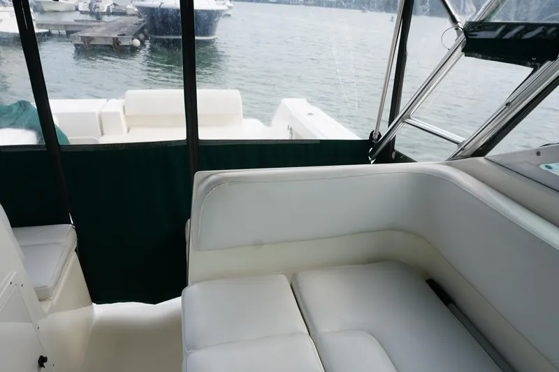 Slide: The Image of 2002 Pursuit 2865 Denali boat interior with white seating and lake view. - 29