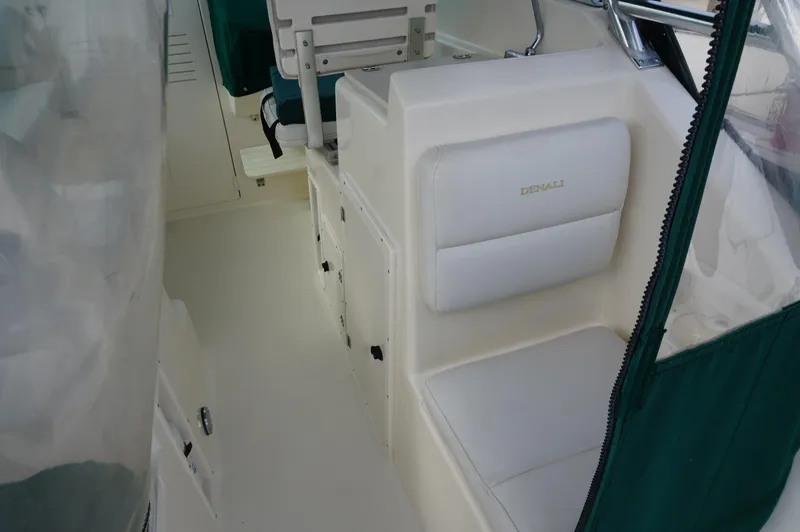 Slide: The Image of 2002 Pursuit 2865 Denali boat interior with white seating and green accents. - 30