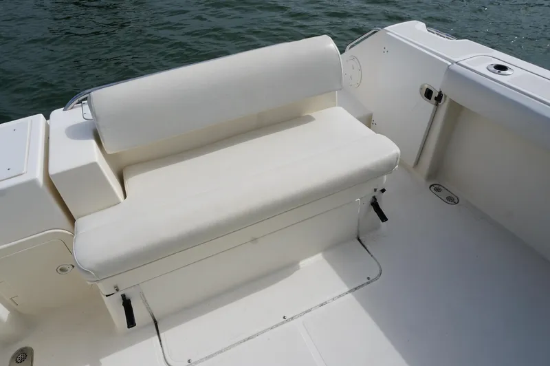 Slide: The Image of White seating area on a 2002 Pursuit 2865 Denali boat, near water. - 4