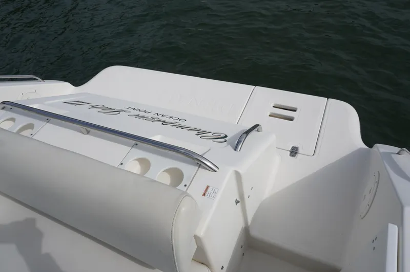 Slide: The Image of 2002 Pursuit 2865 Denali boat deck with seating and railing, near water. - 6