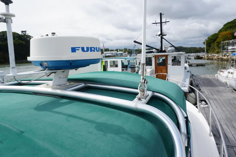 Slide: The Image of 2002 Pursuit 2865 Denali boat with radar, docked in a marina. - 9