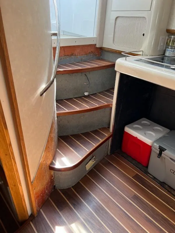 Slide: The Image of Interior stairs of 1995 Sea Ray 450 Sundancer with wood finish and compact kitchen area. - 17