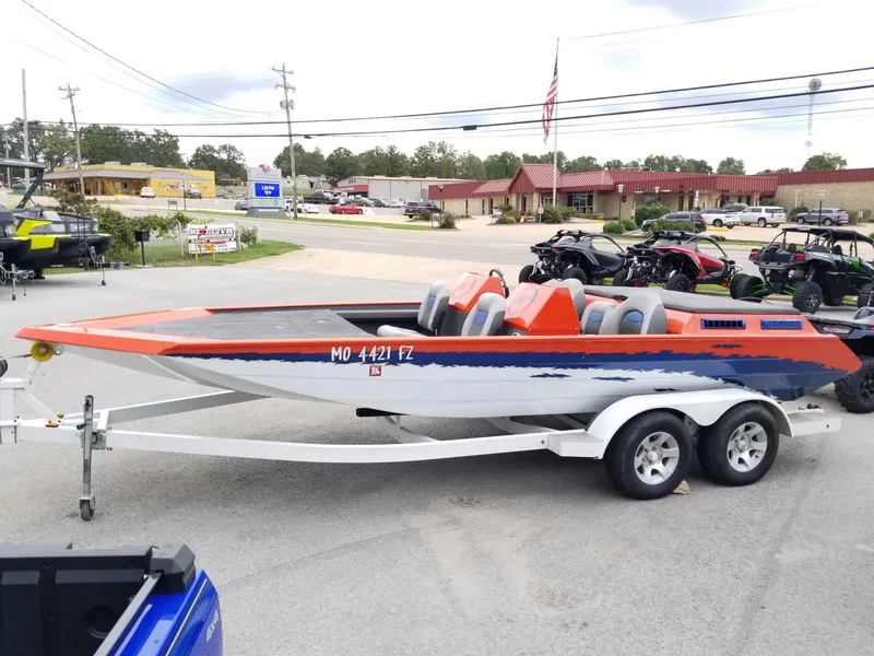 Slide: The Image of Custom 2012 welded boat on trailer, orange and blue design, parked in lot. - 9