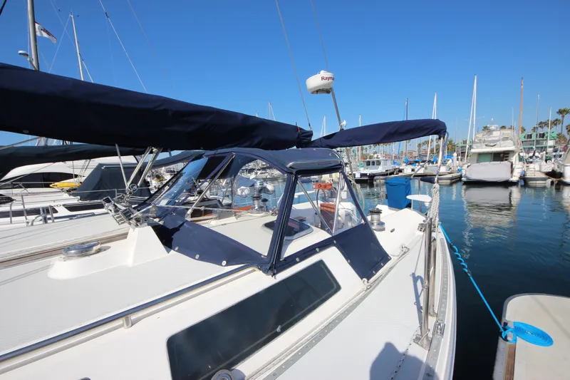 Slide: The Image of 1993 Catalina 42 MKI sailboat docked in marina, featuring blue canvas covers and clear skies. - 20