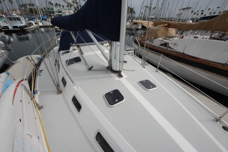 Slide: The Image of 1993 Catalina 42 MKI sailboat deck view in marina, featuring hatches and rigging. - 25