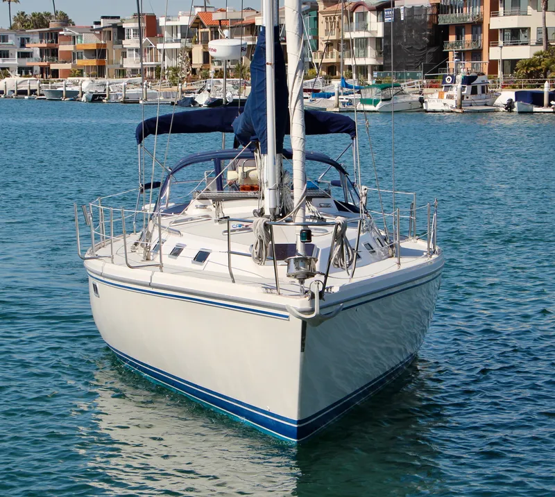 Slide: The Image of 1993 Catalina 42 MKI sailboat docked in a marina, surrounded by waterfront buildings. - 3