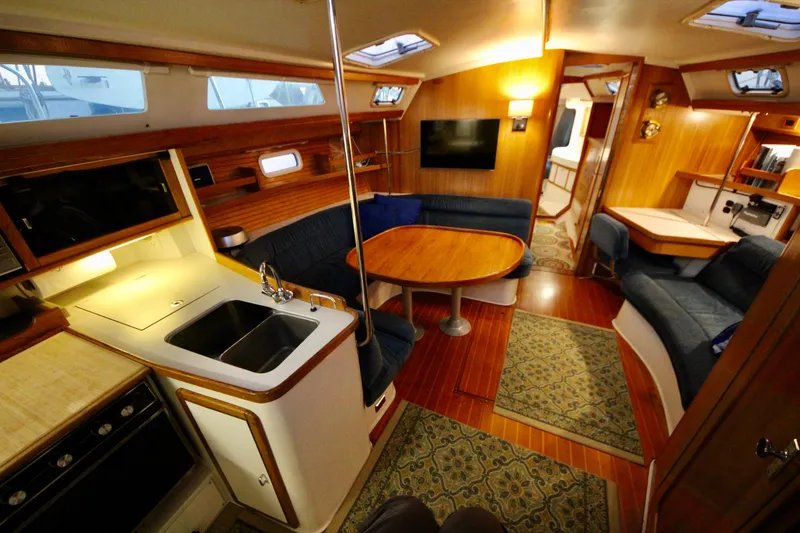 Slide: The Image of Interior of a 1993 Catalina 42 MKI sailboat, featuring a cozy dining area and kitchen. - 6